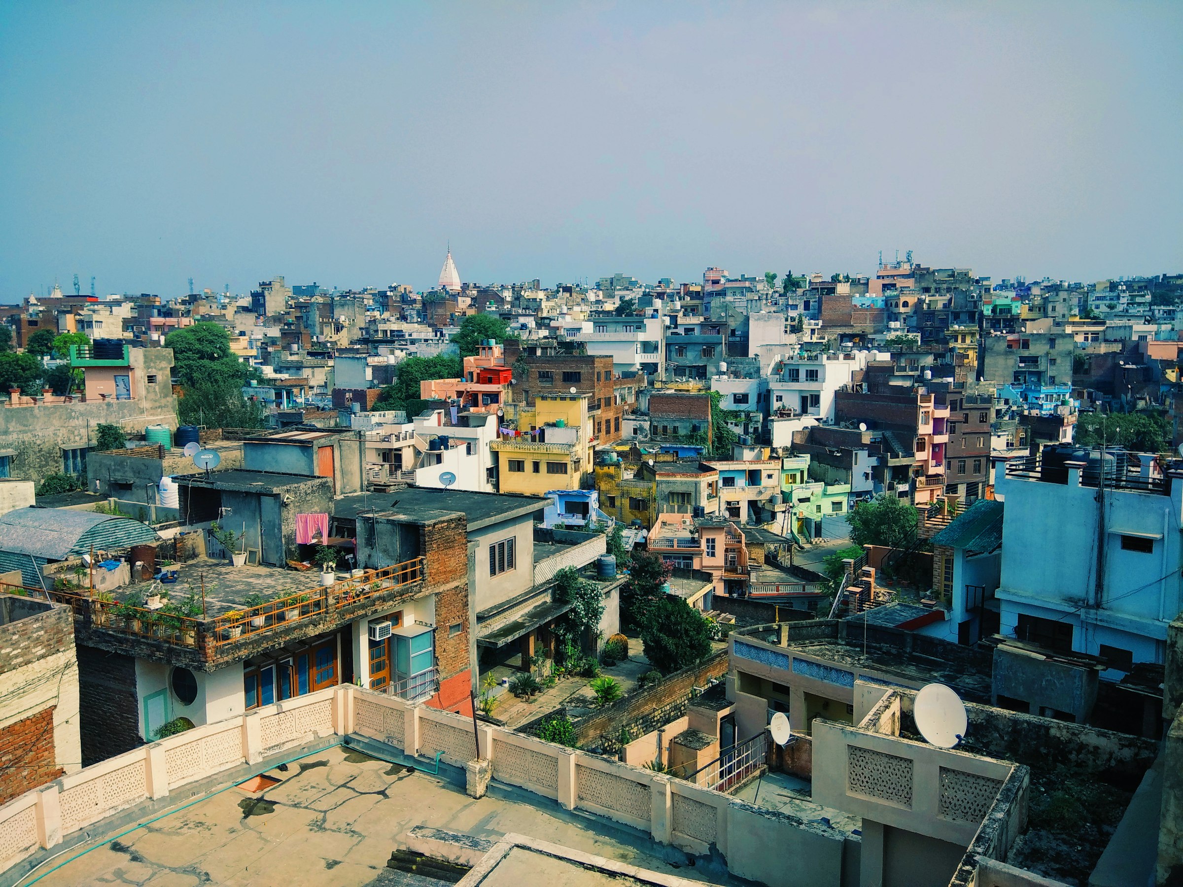 Dense rooftops with water tanks across an Indian city