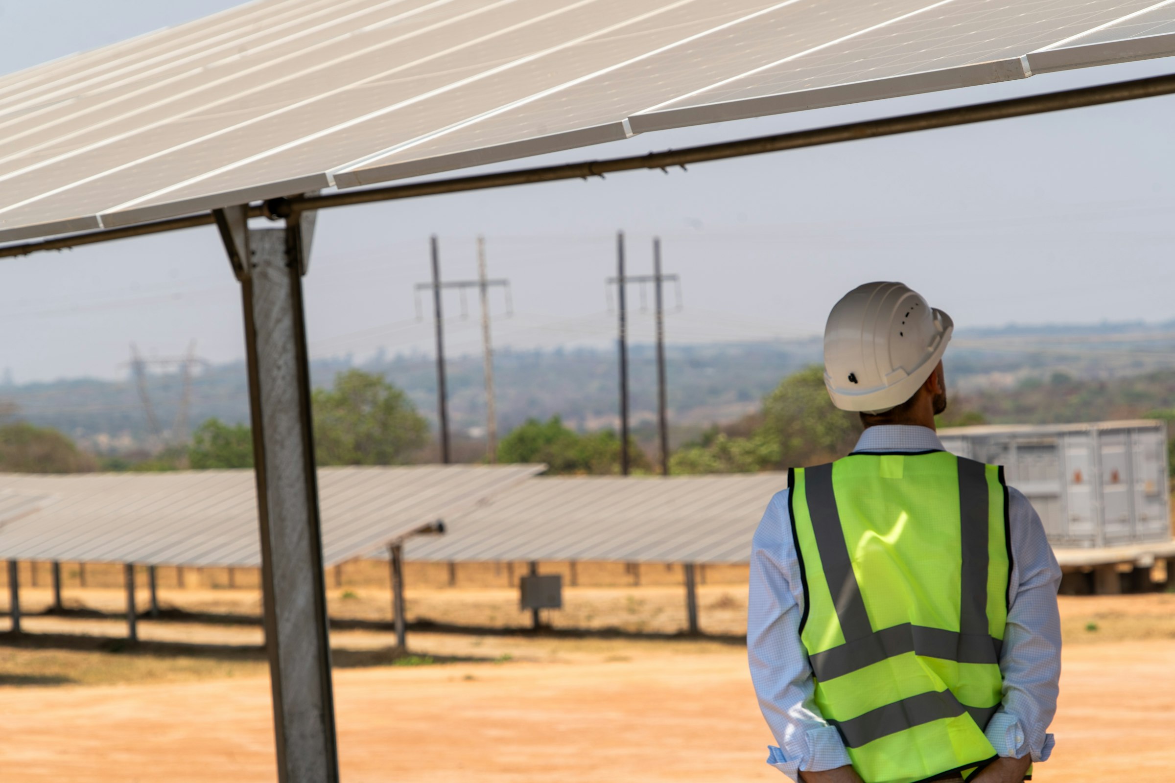 A technician in a safety vest beside an array
