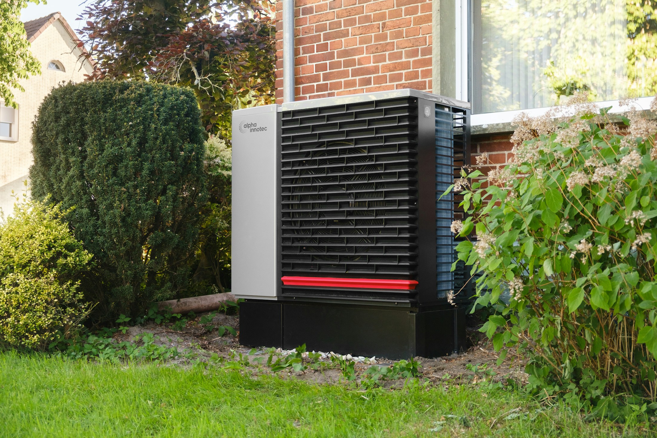 An air source heat pump beside a brick house