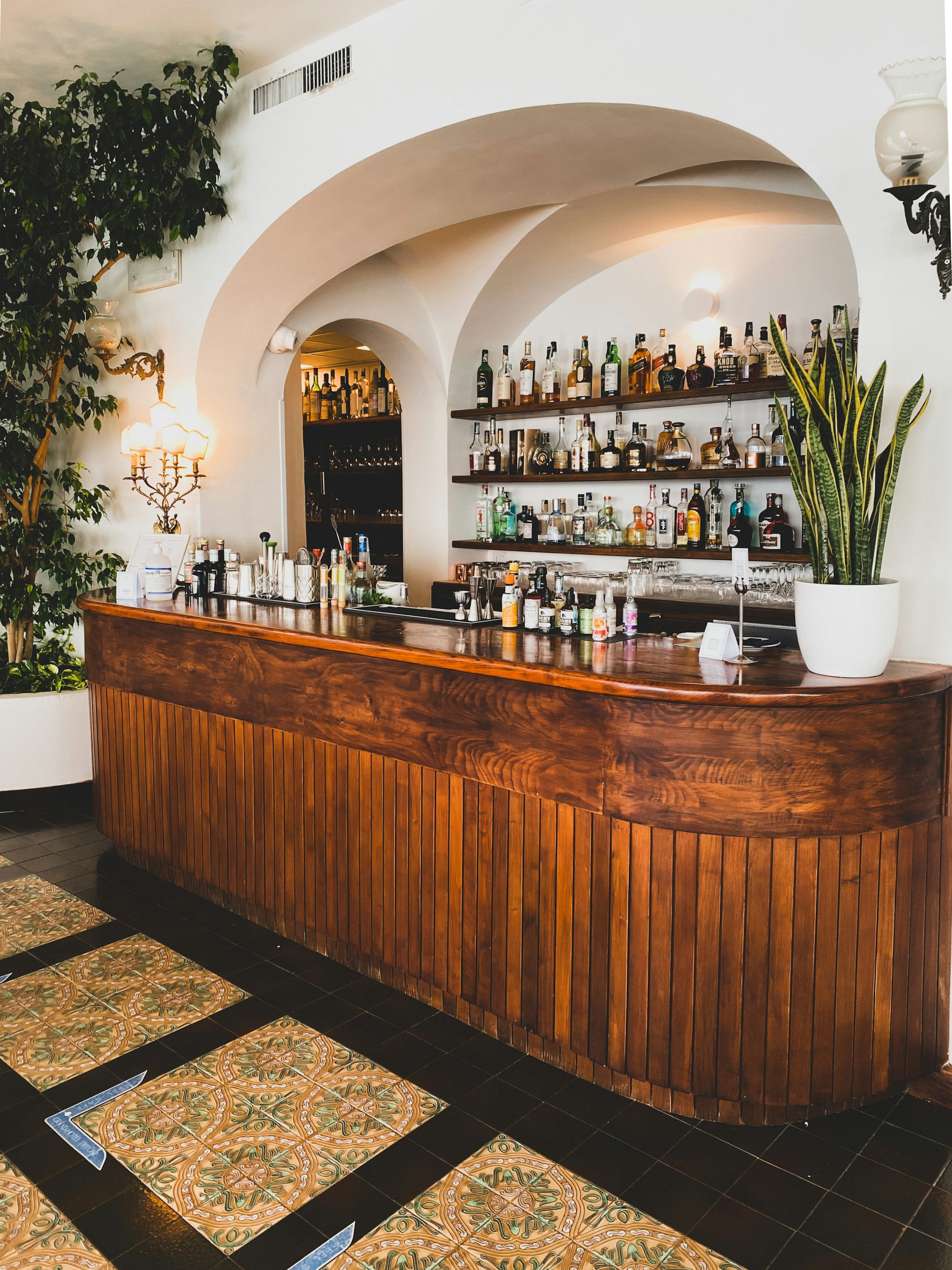 A wooden bar counter under a plastered arch