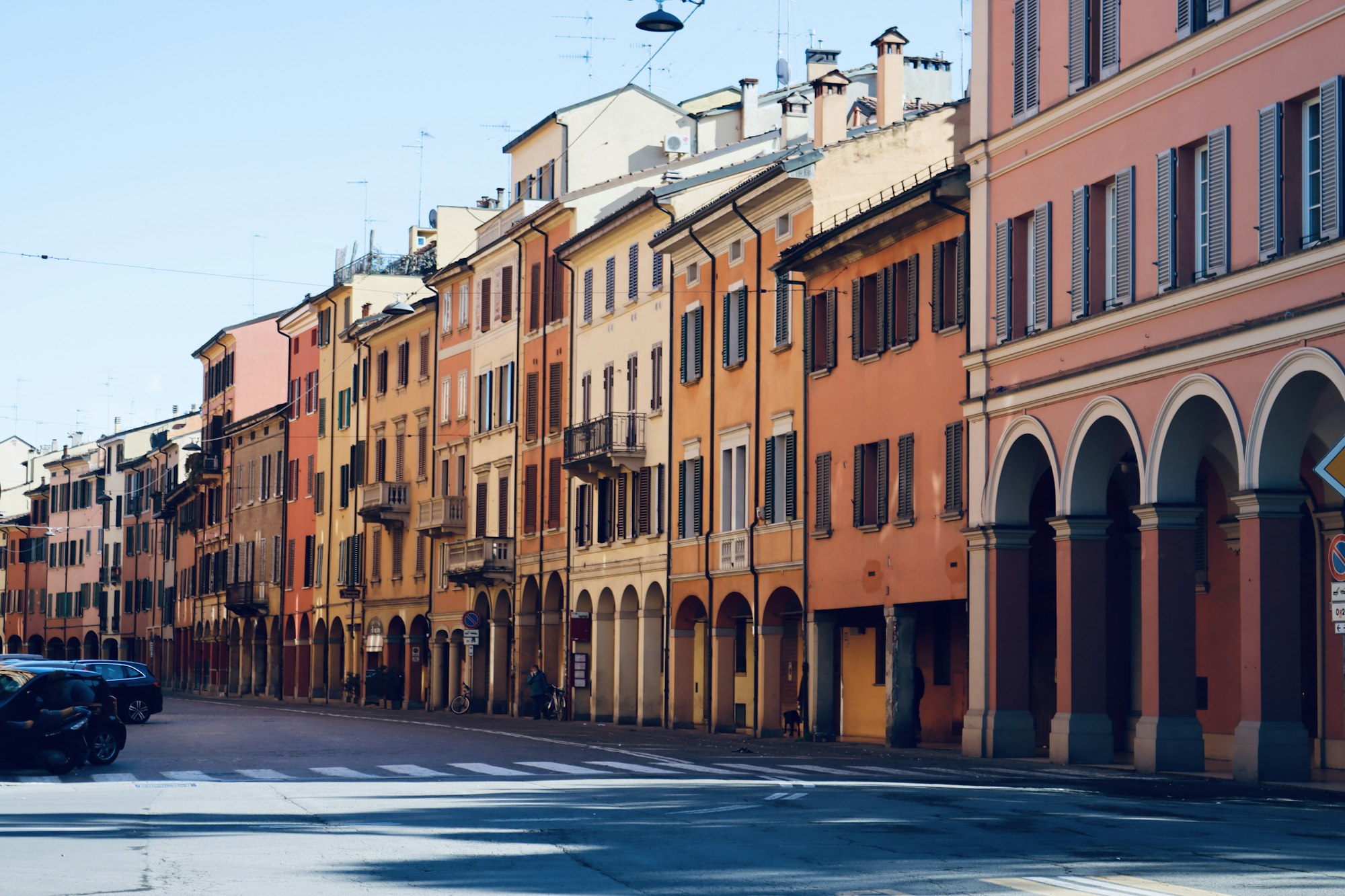 A Bolognese street lined with porticoes and pastel facades