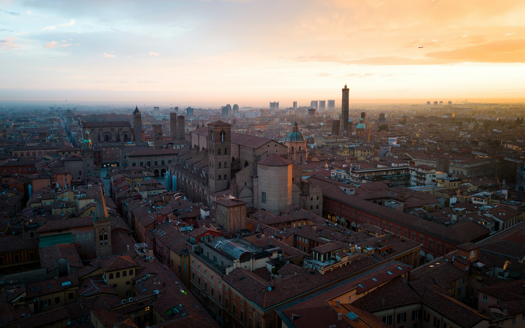 Bologna's terracotta rooftops at sunset with the towers behind