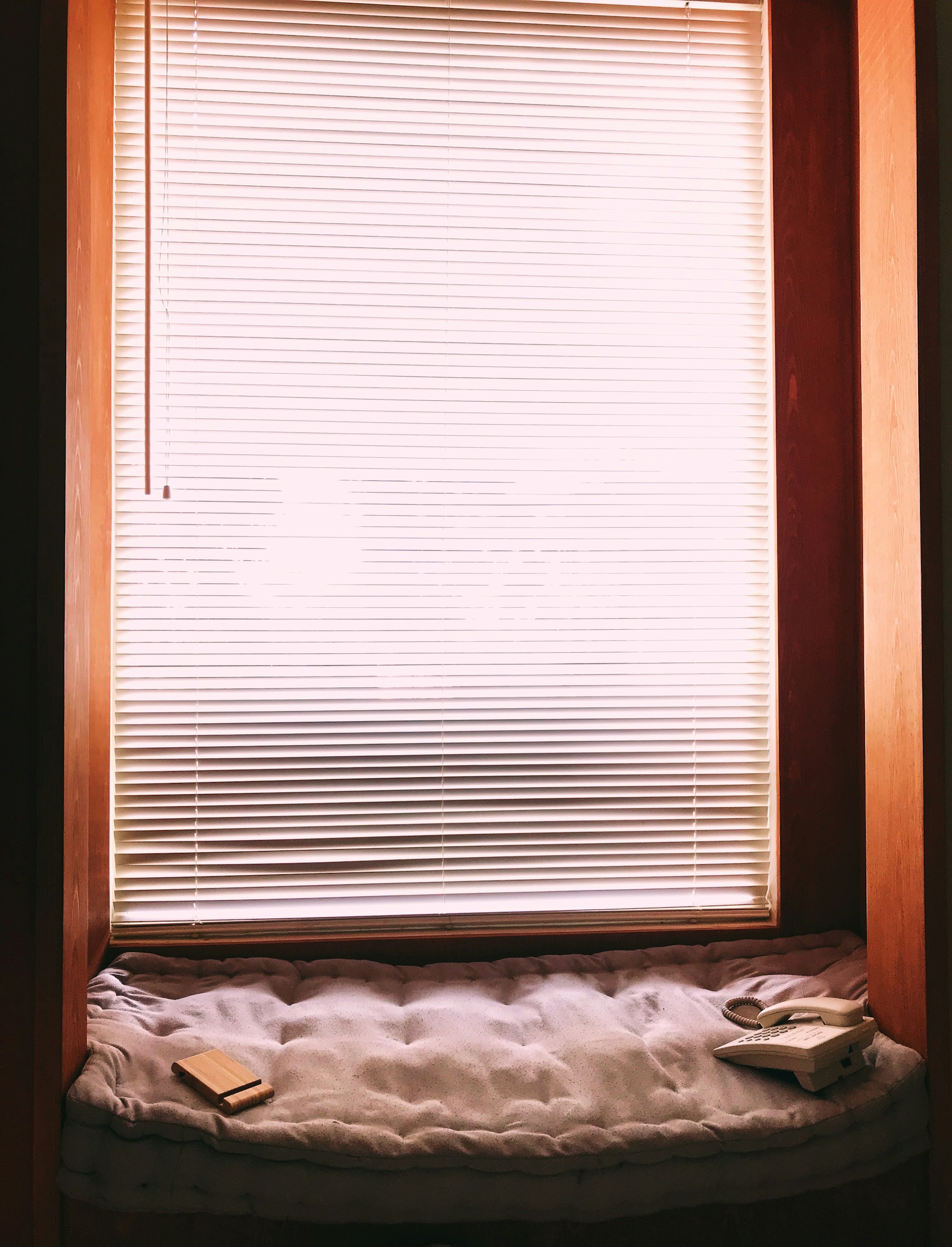 A deep window reveal with a cushioned seat and a lowered blind