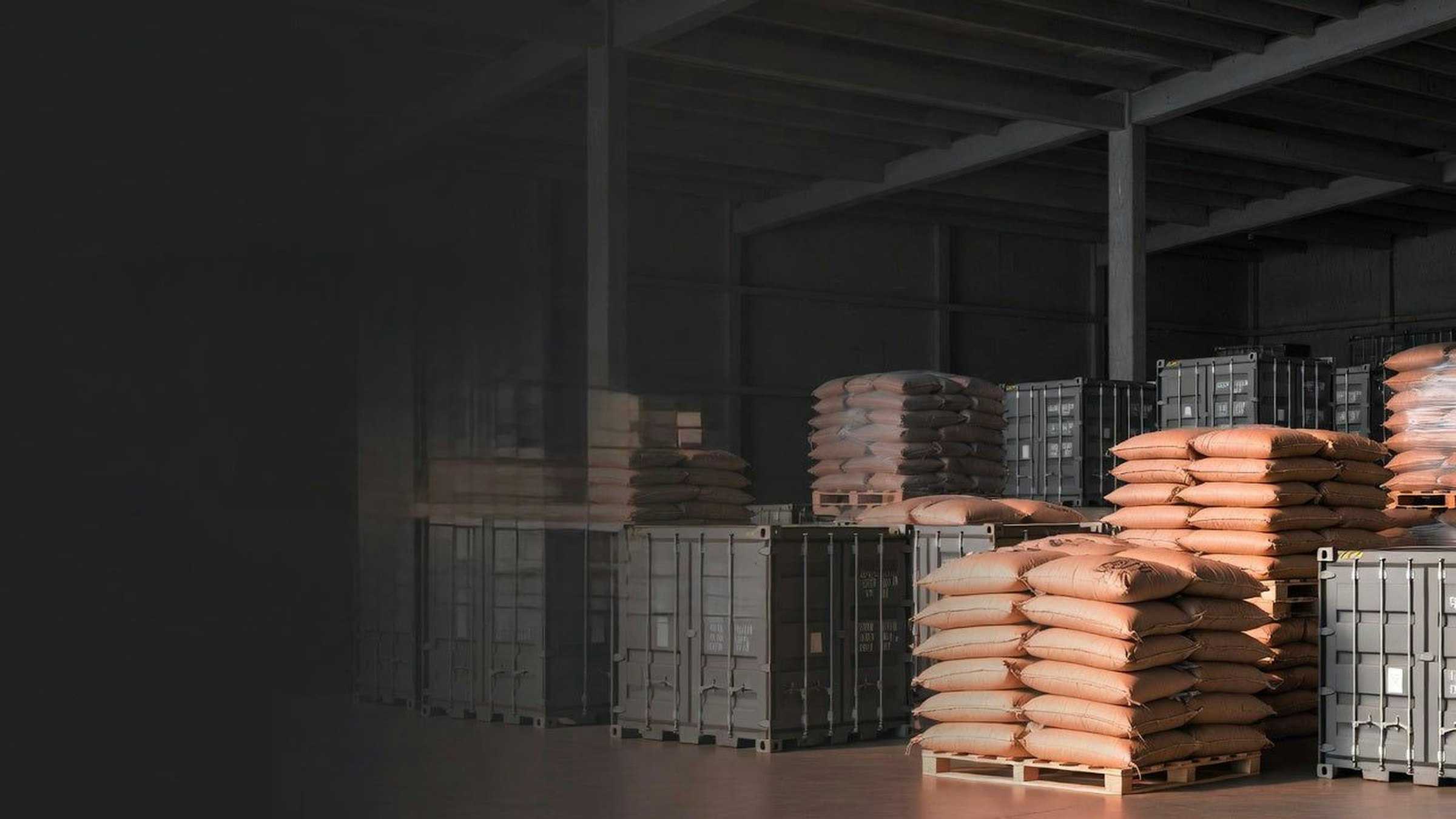 Stacked coffee sacks and crates in a dark warehouse
